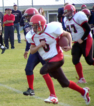 Kyle Daly breaks past the line of scrimmage on his way to a touchdown. At right is Ronnie Chandler.