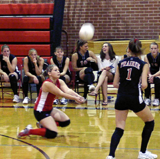 Shandrie Poxleitner goes to her knees to dig up a Lapwai serve. Also shown are Randi Schumacher and the Prairie bench.