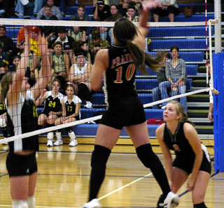 Nicole Nida spikes the ball. Watching is Carolyn Sonnen who had just made the set.