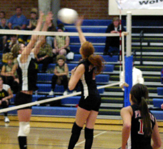 Sarah Arnzen spikes past a Timberline blocker. At right is Nicole Nida.