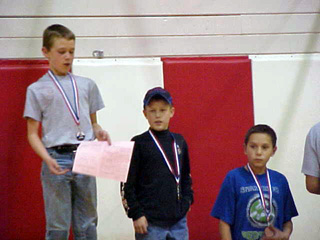 Kade Perrin, gold medal, left, and Alex Duman, silver medal, center, receive their awards.