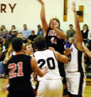 J.D. Riener shoots a lay-up at Kamiah. Back to the camera is Corey Schaeffer.
