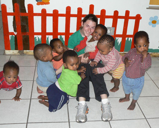 Brenna Riggers with many of the orphans to Bethany Place of Safety in South Africa.