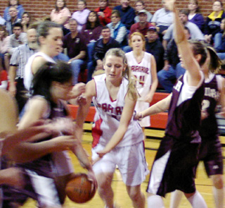Kylie Uhlorn goes after a loose ball. At left is Randi Schumacher while in the background is Sarah Arnzen.