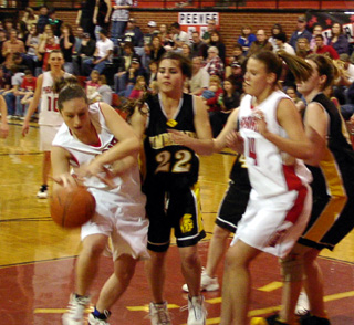 Kaylee Uhlenkott goes after a loose ball as Becky Gehring watches.