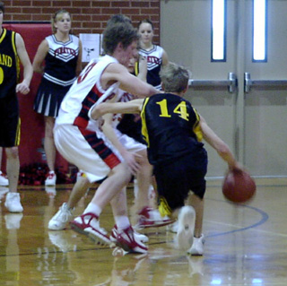 Tyler Forsmann appears to be on the receiving end of an offensive foul as he defends the Highland ballhandler.