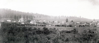 The people of the Keuterville area gather to play a game of baseball.  The present Holy Cross Church stands out in the background.  Circa 1920.
