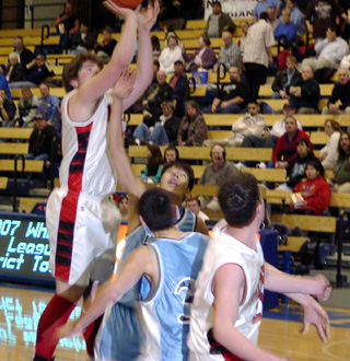 J.D. Riener puts up a shot in the lane. Corey Schaeffer at right is ready for a rebound.
