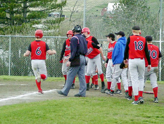 Dan Riener is greeted at home plate after hitting a grand slam homer that cut Kendrick's lead to 3 runs.
