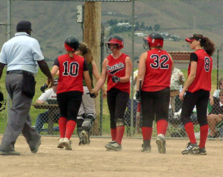 Meghan VanderPas is greeted at home after her 2-run home run in the championship game.