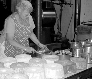 Claudia Gehring volunteers to trim some of the dozens ofcakes for the famous raspberry shortcakes available at the Raspberry Festival.