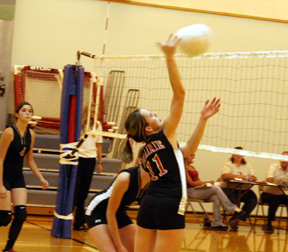 Alli Holthaus gets an opportunity to spike the ball. At left is Sam Frei and hidden behind Alli is Kim Schaeffer.