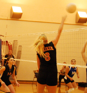 Chelsea Long spikes the ball from the right side. #10 is Tiffany Schaeffer.