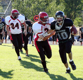 Conner Rieman is about to tackle the Mustang QB for a loss. In the background is Nick Johnson.