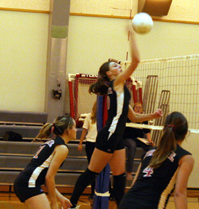 Tiffany Schaeffer spikes the ball against Orofino. Also shown are setter Alli Holthaus, 11, and Sam Frei, 4.