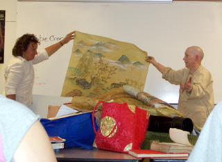 Sonesa Lundmark and Debbie Chan hold up an example of Chinese painting.