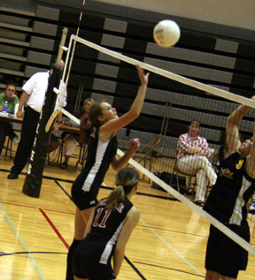 Kim Schaeffer gets ready to hit the ball over the net. #11 is Alli Holthaus.