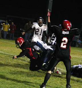 Nick Johnson, normally an offensive lineman, scores the game-ending touchdown as Conner Rieman signals the score.