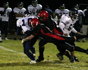 Branden Waller and Kyler Shumway tackle Lapwai's Justin Hernandez for a loss.