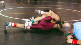 Alex Duman wrestles is about to pin his opponent.