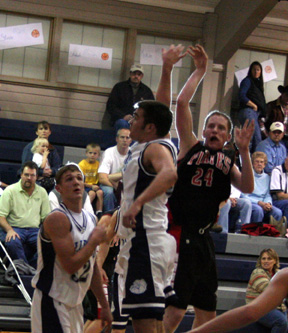 Tyler Forsmann gets a shot past Grangeville's Nels Solberg. The aura effect is from a camera flash behind him.