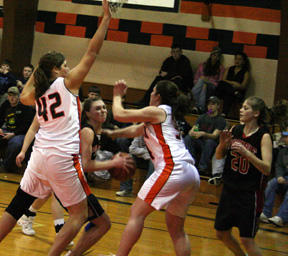 Tiffany Schaeffer looks for an opening to the hoop. At right is Kim Schaeffer.