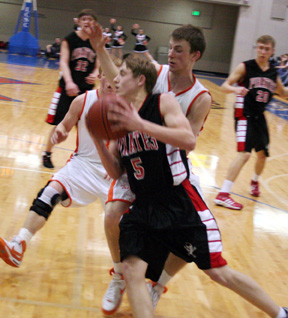 Kyle Daly drives past a pair of Troy players.