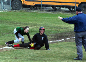 Kara Guyer looks at the umpire as he gives the safe sign at third base.