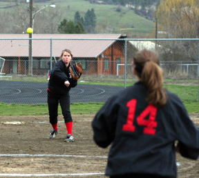 Kara Guyer throws to first for an out at Kamiah. Kim Schaeffer is back to the camera playing first.