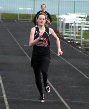 NaTosha Schaeffer comes down the final 100 in the 4x200 relay. She teamed with Amber Frei, Kylee Simmons and Katie Nuxoll to take 3rd in the event. In the background is Casey Bruegeman who anchored a second Prairie team in the event.