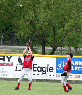 Eric Daly makes a catch in centerfield against Lewis County. At right is Silas Whitley.