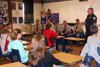 Cottonwood Police Chief Terry Cochran speaks to 8th graders. Seated to his right are five inmates from NICI who shared their experiences in the choices they made that eventually led them to where they are now,