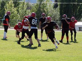 The 1st team offense runs a play against the 2nd team defense during practice.