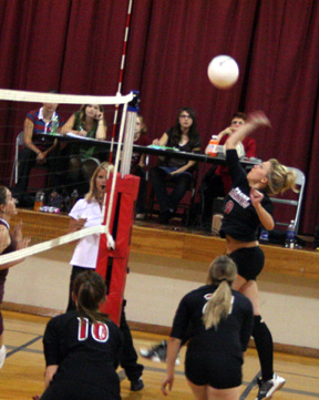 Brianne Stubbers, normally a setter, gets a chance to spike the ball. Also shown are Kayla Johnson, 10, and Jennifer Enneking.