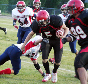 Kyle Daly runs through a tackle. Kyle Shumway is at right.