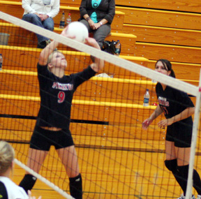 Brianne Stubbers sets the ball. At right is Sam Johnson.