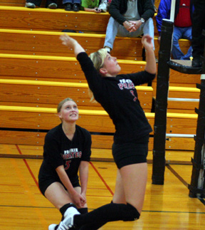 Chelsea Long winds up for a spike. Watching is Leora Laurino.