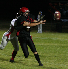 Devin Schmidt pitches out just before he's hit by a defender.