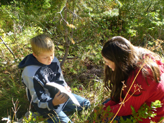 Bryson Higgins and Rosie Trautman are using their field guide book to help identify species of tree in Ponderosa State Park.