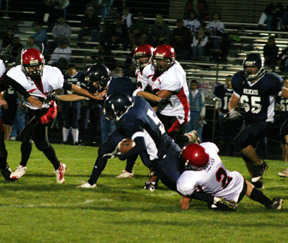Conner Rieman tackles the Lapwai ballcarrier while it appears the Prairie defender at left is being held by the Lapwai blocker.