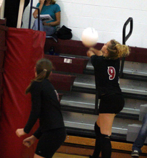 Brianne Stubbers goes out of bounds to bump the ball back into play. At left is Megan Sigler.