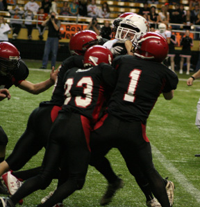 Cody Miller, David Sigler and others gang tackle a Troy runner.