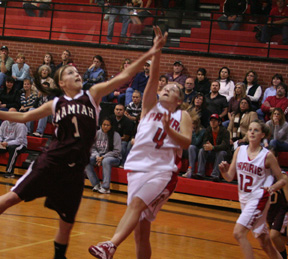 Jennifer Enneking goes for a reverse lay-up. At right is NaTosha Schaeffer.