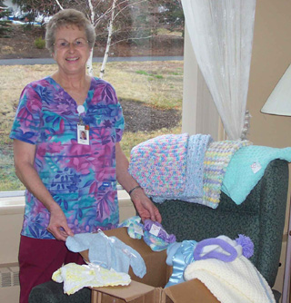 Marilyn Becker, an SMH employee for over 40 years, displays donated items from Stitches from the Heart.