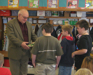Ladd Arnoti receives a Christmas gift from 4th graders after telling them about Hungarian Christmas traditions.