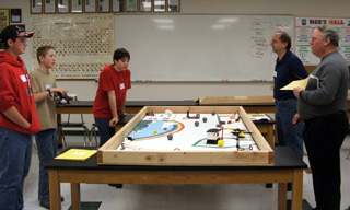 Matthew Jungert, Drew Cochran, and Chris Bradley talking to the judges about how they programmed their robot for the missions