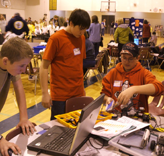 Drew Cochran, Chris Bradley, and Matthew Jungert programming their robot getting ready for competition
