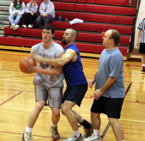 Pat McWilliams guards Corey Schaeffer while Clinton Holthaus looks on in the men's alumni game last Friday, Jan. 2.