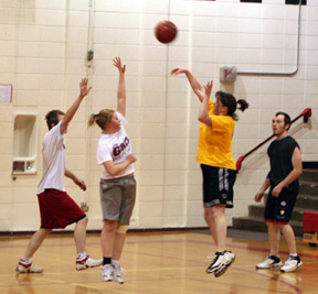 Michelle (Becker) Schaeffer shoots over Alyssa Frei in the women's alumni game. With only 6 women available, some of the men were recruited to fill out the teams. At left is Jared Nau while at right is Zack Frei.