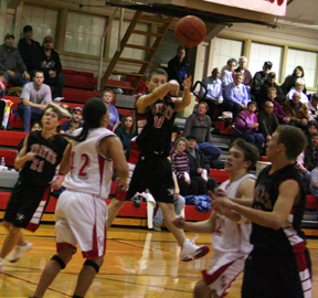 Kyle Holthaus makes a jump pass across the lane. At left is Conner Rieman and at right is Devin Schmidt.